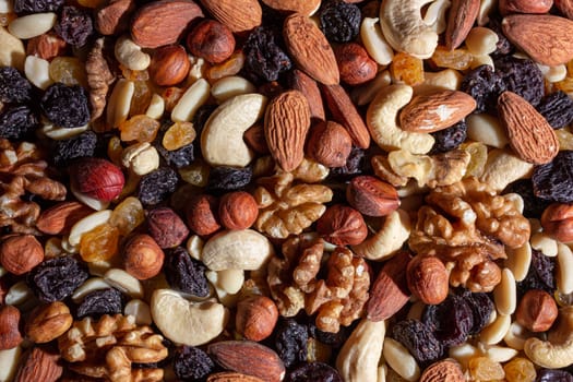 Mixed Nuts: Almonds, Walnuts, Cashews, Peanuts, Hazelnuts, Dried Prunes and Raisins. Different Nut Mix. Background from Various Nuts and Dried Fruits