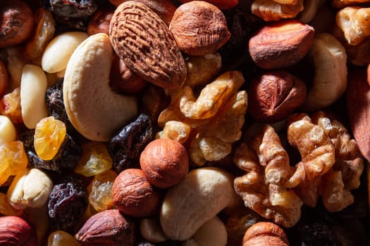 Mixed Nuts: Almonds, Walnuts, Cashews, Peanuts, Hazelnuts, Dried Prunes and Raisins. Different Nut Mix. Background from Various Nuts and Dried Fruits