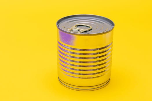 Unopened Tin Can with Blank Edge on Yellow Background. Canned Food. Aluminum Can for Safe and Long Term Storage of Food. Steel Sealed Food Storage Container