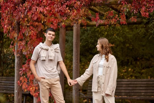 Young Cute Female Hugs Boyfriend. In Autumn Outdoor. Lovers Walking in Park. Attractive Funny Couple. Lovestory in Forest. Man and Woman. Cute Lovers in the Park. Family Concept. Happy Couple.