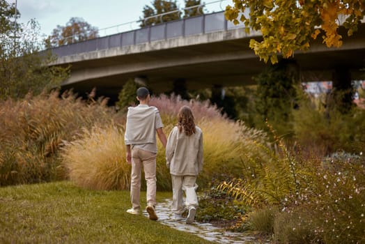 Young Cute Female Hugs Boyfriend. In Autumn Outdoor. Lovers Walking in Park. Attractive Funny Couple. Lovestory in Forest. Man and Woman. Cute Lovers in the Park. Family Concept. Happy Couple.