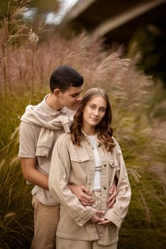 Young Cute Female Hugs Boyfriend. In Autumn Outdoor. Lovers Walking in Park. Attractive Funny Couple. Lovestory in Forest. Man and Woman. Cute Lovers in the Park. Family Concept. Happy Couple.