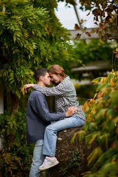 Young Cute Female Hugs Boyfriend. In Autumn Outdoor. Lovers Walking in Park. Attractive Funny Couple. Lovestory in Forest. Man and Woman. Cute Lovers in the Park. Family Concept. Happy Couple.