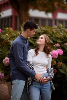 Young Cute Female Hugs Boyfriend. In Autumn Outdoor. Lovers Walking in Park. Attractive Funny Couple. Lovestory in Forest. Man and Woman. Cute Lovers in the Park. Family Concept. Happy Couple.