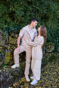 Young Cute Female Hugs Boyfriend. In Autumn Outdoor. Lovers Walking in Park. Attractive Funny Couple. Lovestory in Forest. Man and Woman. Cute Lovers in the Park. Family Concept. Happy Couple.