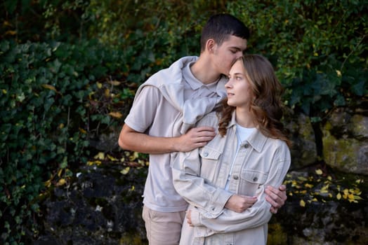 Young Cute Female Hugs Boyfriend. In Autumn Outdoor. Lovers Walking in Park. Attractive Funny Couple. Lovestory in Forest. Man and Woman. Cute Lovers in the Park. Family Concept. Happy Couple.