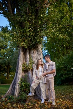 Young Cute Female Hugs Boyfriend. In Autumn Outdoor. Lovers Walking in Park. Attractive Funny Couple. Lovestory in Forest. Man and Woman. Cute Lovers in the Park. Family Concept. Happy Couple.