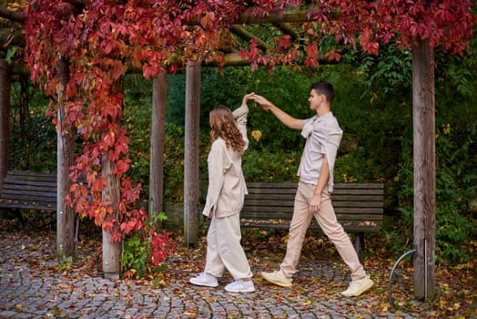 Young Cute Female Hugs Boyfriend. In Autumn Outdoor. Lovers Walking in Park. Attractive Funny Couple. Lovestory in Forest. Man and Woman. Cute Lovers in the Park. Family Concept. Happy Couple.