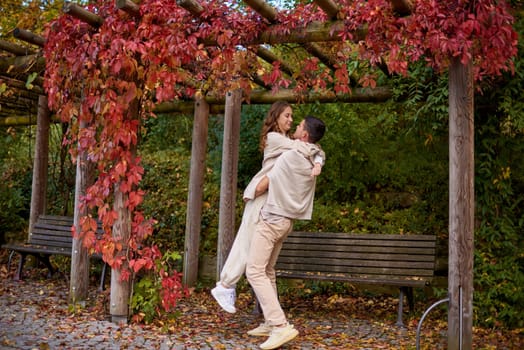 Young Cute Female Hugs Boyfriend. In Autumn Outdoor. Lovers Walking in Park. Attractive Funny Couple. Lovestory in Forest. Man and Woman. Cute Lovers in the Park. Family Concept. Happy Couple.