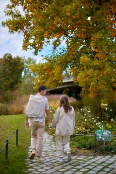 Young Cute Female Hugs Boyfriend. In Autumn Outdoor. Lovers Walking in Park. Attractive Funny Couple. Lovestory in Forest. Man and Woman. Cute Lovers in the Park. Family Concept. Happy Couple.