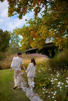 Young Cute Female Hugs Boyfriend. In Autumn Outdoor. Lovers Walking in Park. Attractive Funny Couple. Lovestory in Forest. Man and Woman. Cute Lovers in the Park. Family Concept. Happy Couple.