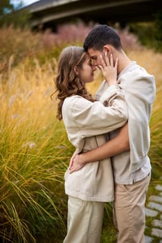 Young Cute Female Hugs Boyfriend. In Autumn Outdoor. Lovers Walking in Park. Attractive Funny Couple. Lovestory in Forest. Man and Woman. Cute Lovers in the Park. Family Concept. Happy Couple.