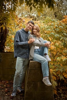 Young Cute Female Hugs Boyfriend. In Autumn Outdoor. Lovers Walking in Park. Attractive Funny Couple. Lovestory in Forest. Man and Woman. Cute Lovers in the Park. Family Concept. Happy Couple.