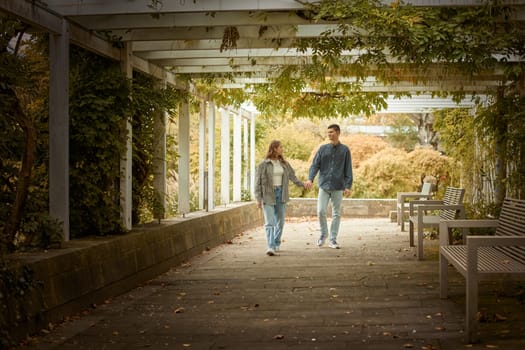 Young Cute Female Hugs Boyfriend. In Autumn Outdoor. Lovers Walking in Park. Attractive Funny Couple. Lovestory in Forest. Man and Woman. Cute Lovers in the Park. Family Concept. Happy Couple.