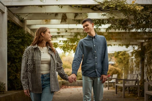 Young Cute Female Hugs Boyfriend. In Autumn Outdoor. Lovers Walking in Park. Attractive Funny Couple. Lovestory in Forest. Man and Woman. Cute Lovers in the Park. Family Concept. Happy Couple.