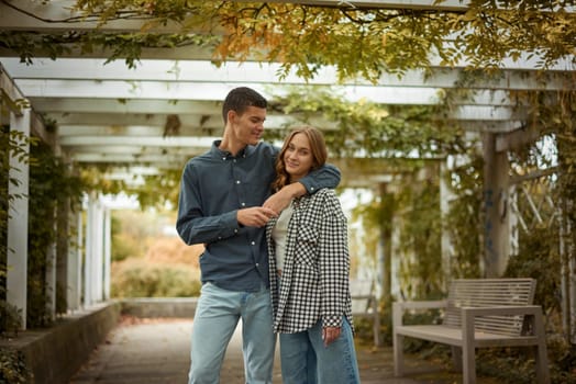 Young Cute Female Hugs Boyfriend. In Autumn Outdoor. Lovers Walking in Park. Attractive Funny Couple. Lovestory in Forest. Man and Woman. Cute Lovers in the Park. Family Concept. Happy Couple.