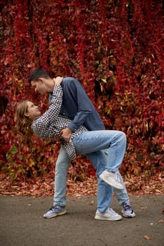 Young Cute Female Hugs Boyfriend. In Autumn Outdoor. Lovers Walking in Park. Attractive Funny Couple. Lovestory in Forest. Man and Woman. Cute Lovers in the Park. Family Concept. Happy Couple.