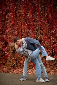 Young Cute Female Hugs Boyfriend. In Autumn Outdoor. Lovers Walking in Park. Attractive Funny Couple. Lovestory in Forest. Man and Woman. Cute Lovers in the Park. Family Concept. Happy Couple.