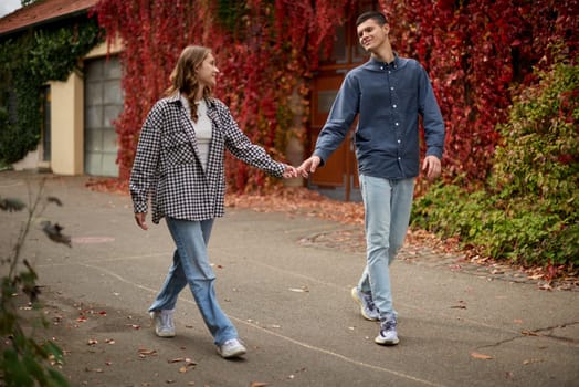 Young Cute Female Hugs Boyfriend. In Autumn Outdoor. Lovers Walking in Park. Attractive Funny Couple. Lovestory in Forest. Man and Woman. Cute Lovers in the Park. Family Concept. Happy Couple.