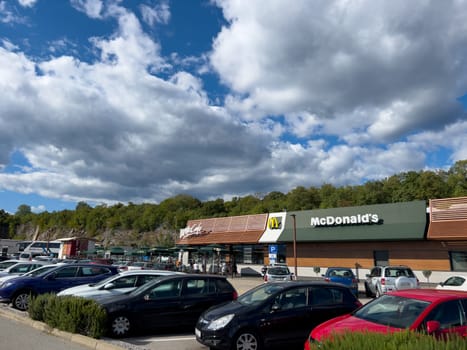 Cars stand in the parking lot near the McDonalds building. High quality photo