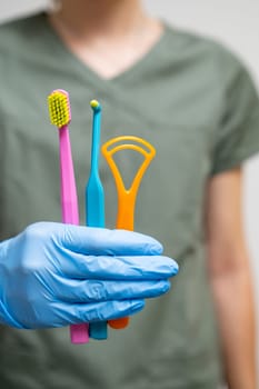Different toothbrushes in dentists hand in rubber gloves