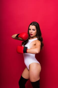 Studio portrait of female seductive boxer in bodysuit and gloves