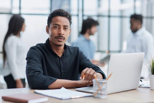 Cheerful businessman working at desk, confident and engaged.