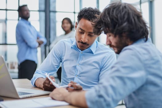 Professionals in businesswear discussing documents in a productive office meeting.