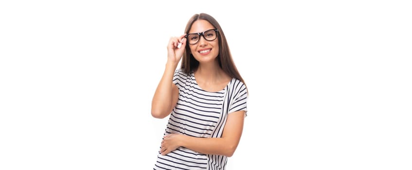 young well-groomed pleasant Caucasian brunette woman in a striped t-shirt posing on a white one with copy space.