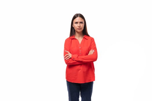 young pretty brunette office worker woman dressed in a red loose shirt on a white background.