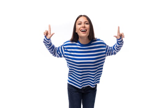 young stylish woman with straight hair is dressed in a loose-fitting striped sweater on a white background.