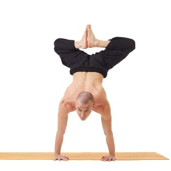 Yogi looking at camera while doing handstand, isolated on white