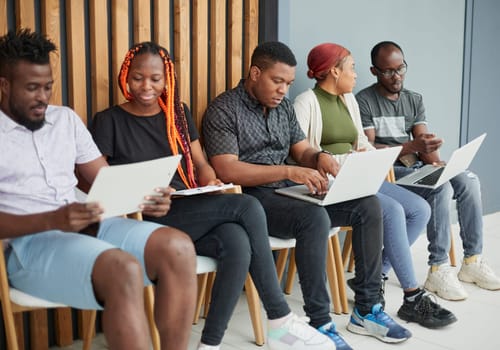 applicants sitting in queue and receiving recruitment files before job interview appointment.