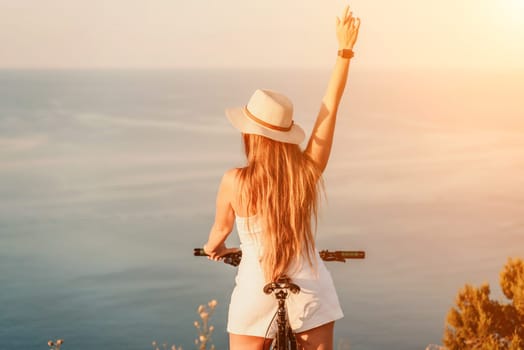 Woman travel bike sea. Happy woman cyclist sitting on her bike, enjoying the beautiful mountain and sea landscape, signifying the idea of an adventurous bike ride