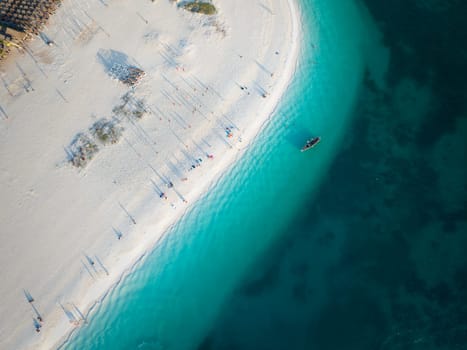 Birds view of dhow boat in the green ocean and wonderful white sandy beach, copy space, Zanzibar in Tanzania.