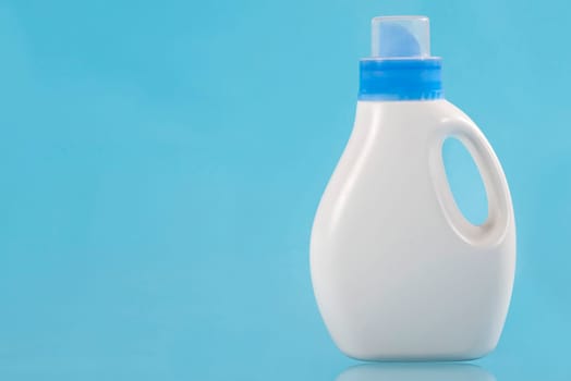 Bottle with detergent on a blue background. Copy Space. Cleaning concept.