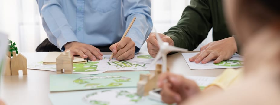 Green business meeting represented renewable energy. Skilled businesspeople discuss green business investment at table with environmental documents. Closeup. Focus on hand. Delineation.