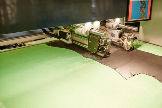 Image of automatic machine cuts leather with laser marking