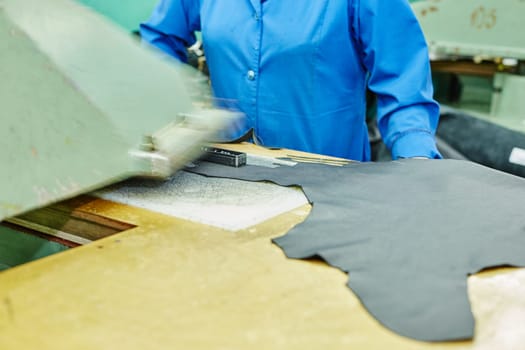 Image of cutting leather using semiautomatic press in workshop