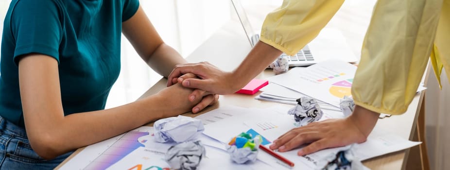 Panorama startup employee holding hand to stressed colleague due to failure, frustrated from no inspiration, lack of idea. Exhausted from overwhelm work and supportive coworker concept. Synergic