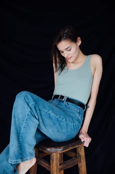 young slender woman in jeans sitting