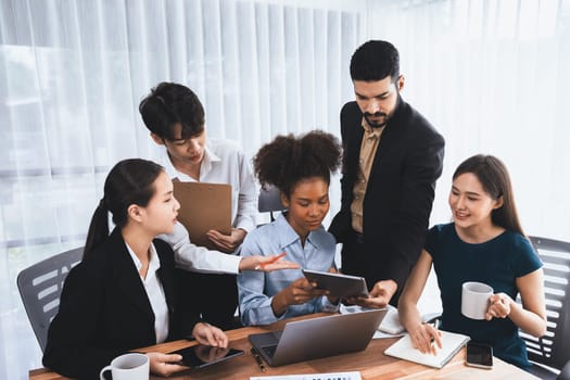 Happy diverse business people work together, discussing in corporate office. Professional and diversity teamwork discuss business plan on desk with laptop. Modern multicultural office worker. Concord