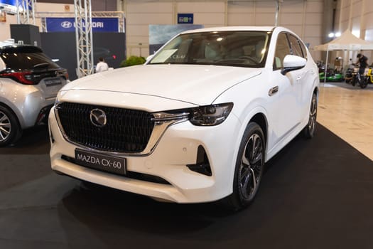 12 MAY 2023, Lisbon, Porugal, Electric car Show in International Fairy of Lisbon - A white car is on display in a showroom