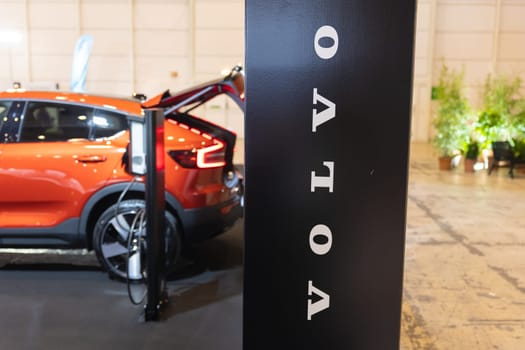 12 MAY 2023, lISBON, Porugal, Electric car Show in International Fairy of Lisbon - An orange car is parked in a showroom