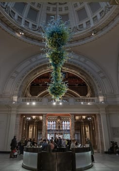 London, UK - Nov 27, 2023 - Metre high, View of Blown glass chandelier in Victoria and Albert Museum hall. Beautiful interior architecture design of The Victoria and Albert Museum. Inner decor. Selective focus.