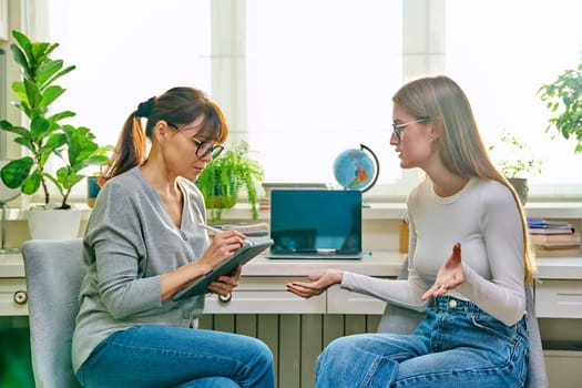 Young teenage girl high school student talking with psychologist, therapist, counsellor, social worker. Mental session therapy, support, psychology, psychotherapy, adolescence, youth concept