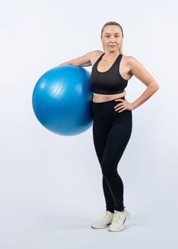 Full body length shot athletic and sporty senior woman with fitness exercising ball on isolated background. Healthy active and body care lifestyle after retirement. Clout