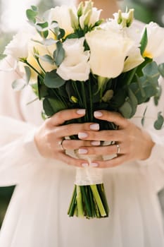 Wedding bouquet in the hands of the bride. Cropped. Faceless. High quality photo