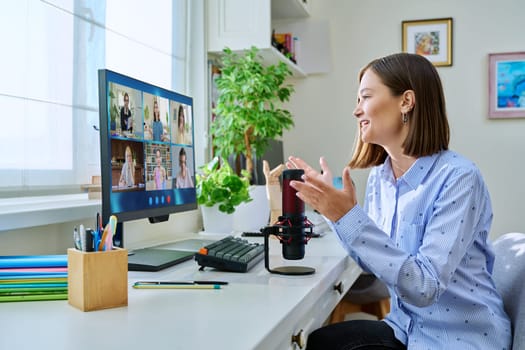 Computer screen with online video conference by group of teenage students, young female teacher in home talking to students. Education wireless technology e-learning virtual lessons distance learning