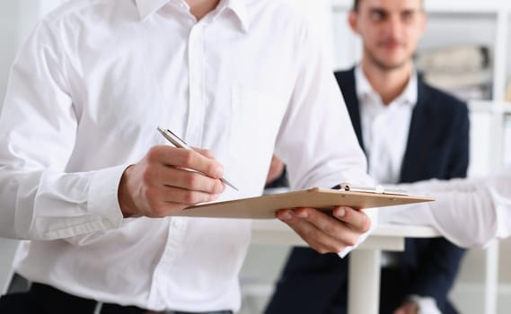 Male arm in shirt hold silver pen and pad making note in office closeup. Deal consult delivery signature financial inspector job fill survey form discuss strategy project negotiation concept
